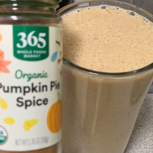 jar of pumpkin spice next to a pumpkin spice protein smoothie